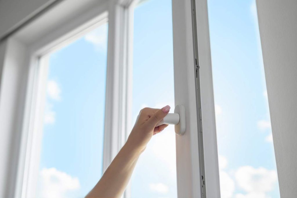 Woman Opening White UPVC Window With Handle