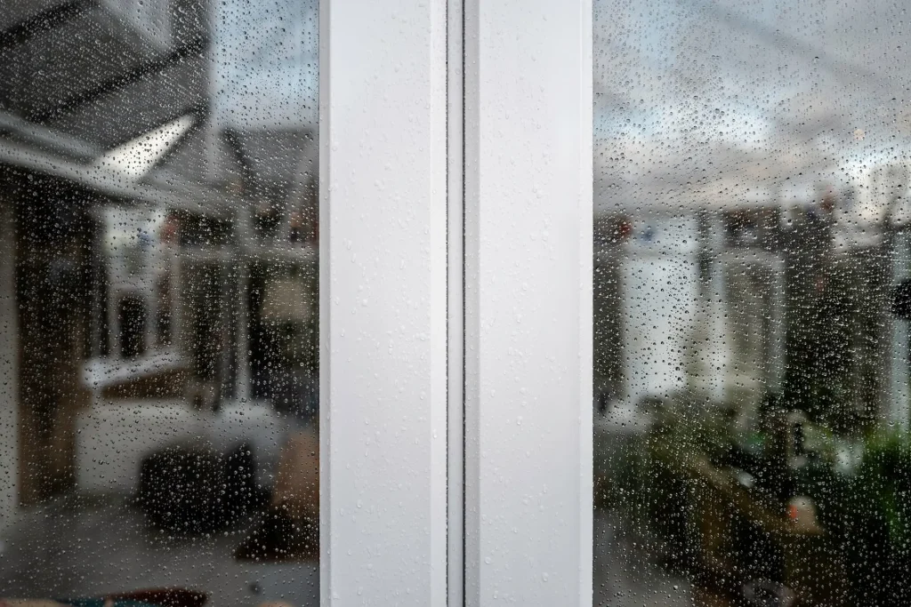 Closeup Of White UPVC Doors With Rain Droplets